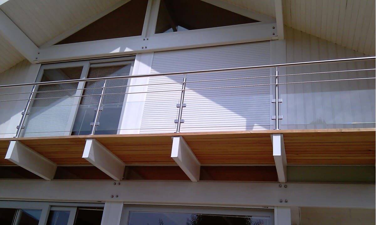 Pour équiper son balcon, notre client à opté pour un garde-corps avec vitres et sous-lisses, fixation sur les poutres bois